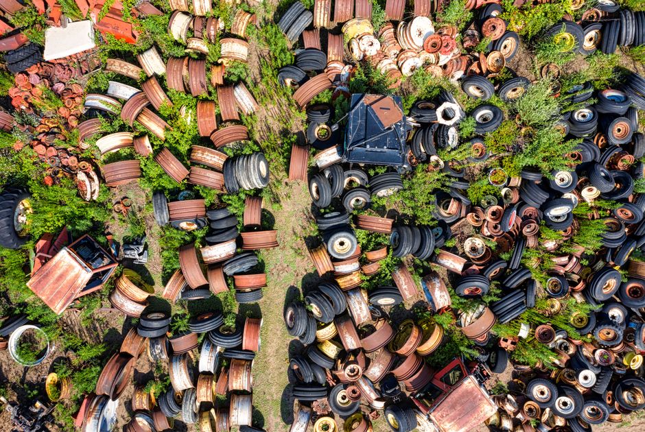 A large heap of mixed waste materials occupying a significant outdoor area, consisting of various types of debris including broken wood, plastic, metal scraps, cardboard, and fabric, all piled togethe